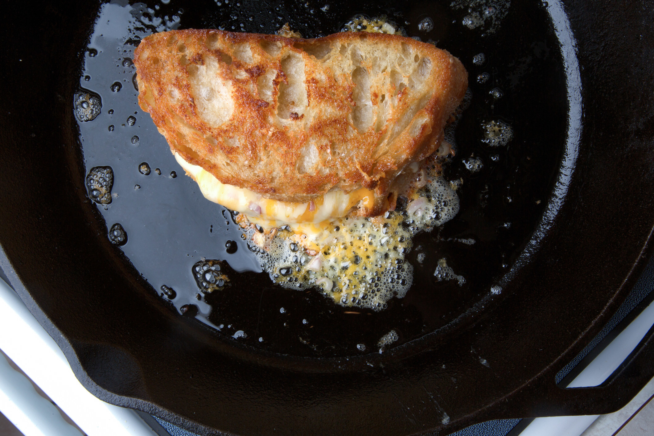 A grilled cheese sizzling in a pan