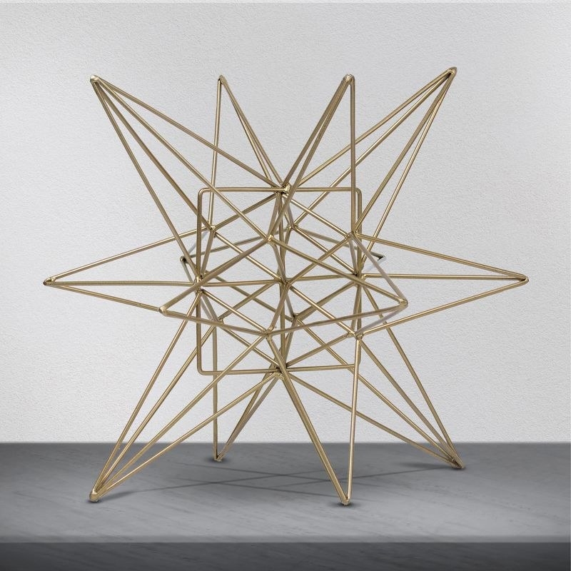 the star-shaped gold metal sculpture on a table