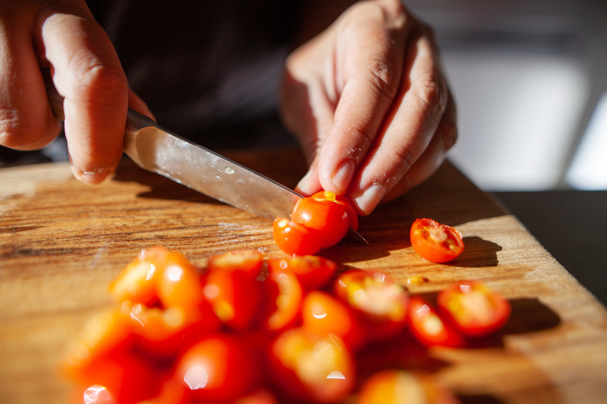 A person slicing cherry tomatoes