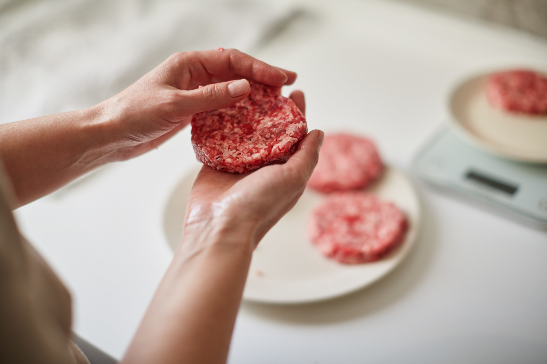 A person shaping hamburger patties