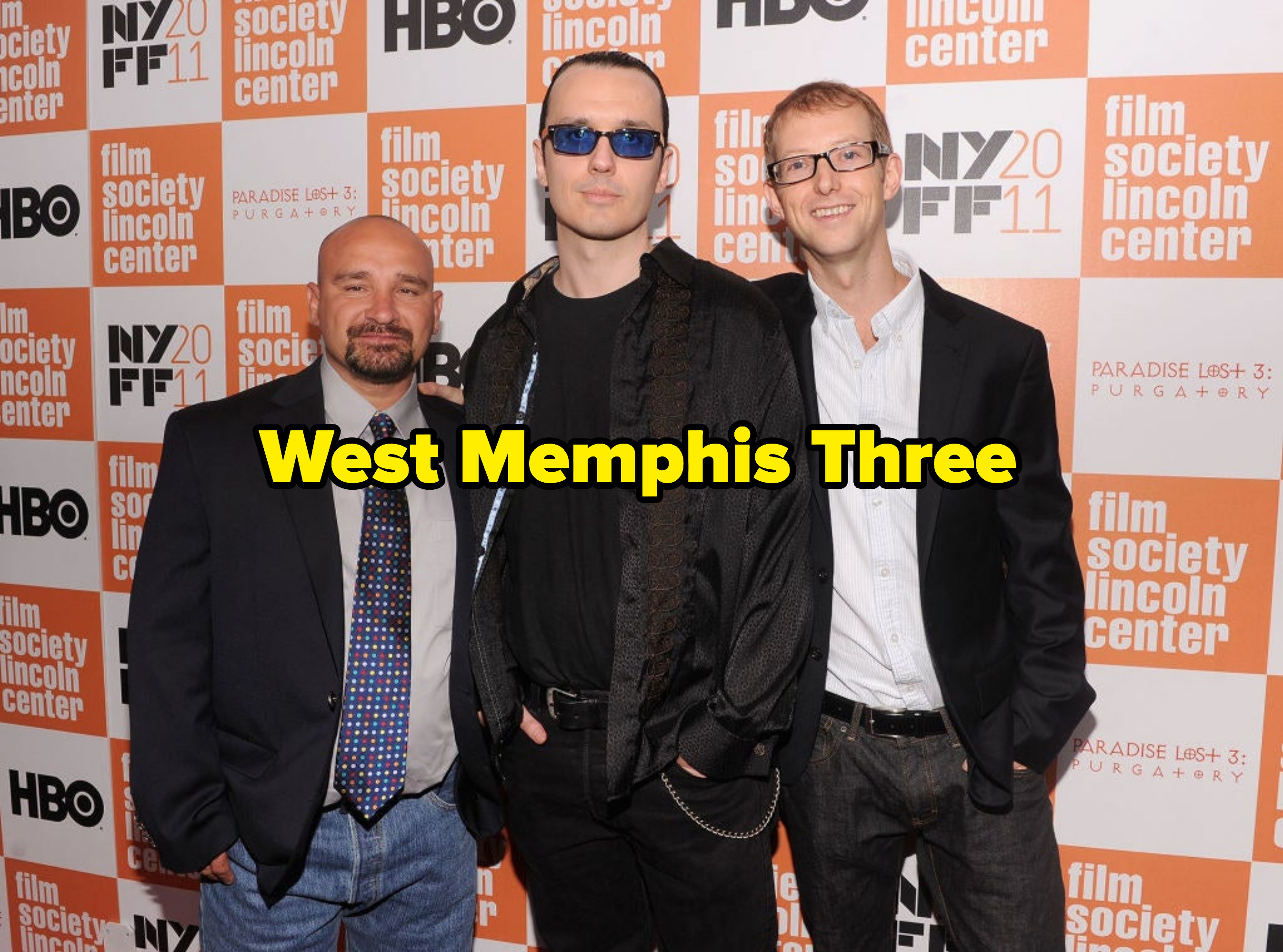 Three men stand in front of a step-and-repeat with the caption &quot;West Memphis Three&quot;