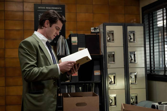 A man in an office looks at a file