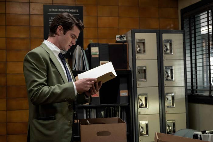 A man in an office looks at a file 