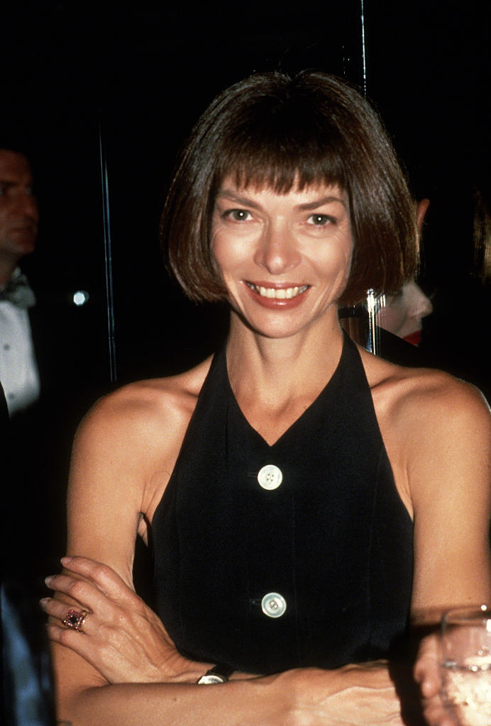 A young Anna Wintour smiling with her arms crossed