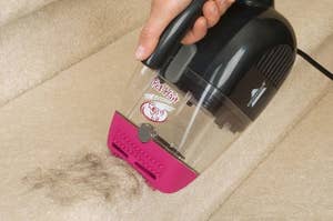 A model using a handheld pet hair erasing vacuum to remove hair from a staircase