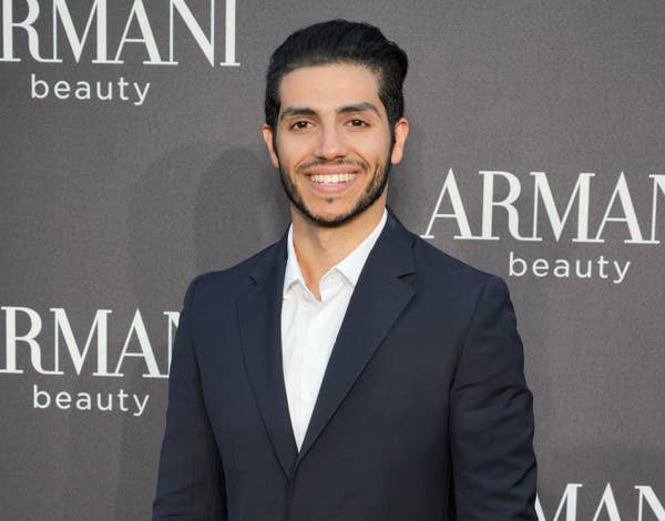 Mena smiles as he wears a suit at a red carpet event