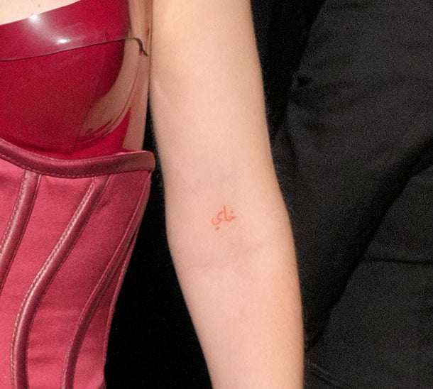 The tattoo is very small and located slightly above her elbow