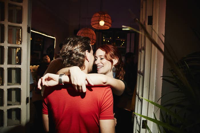 Smiling woman embracing man during party in night club