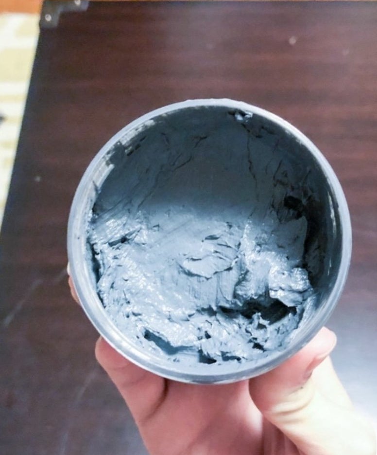 reviewer holding the jar of the clay mud mask open