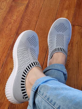 reviewer wearing the knit sneakers in grey