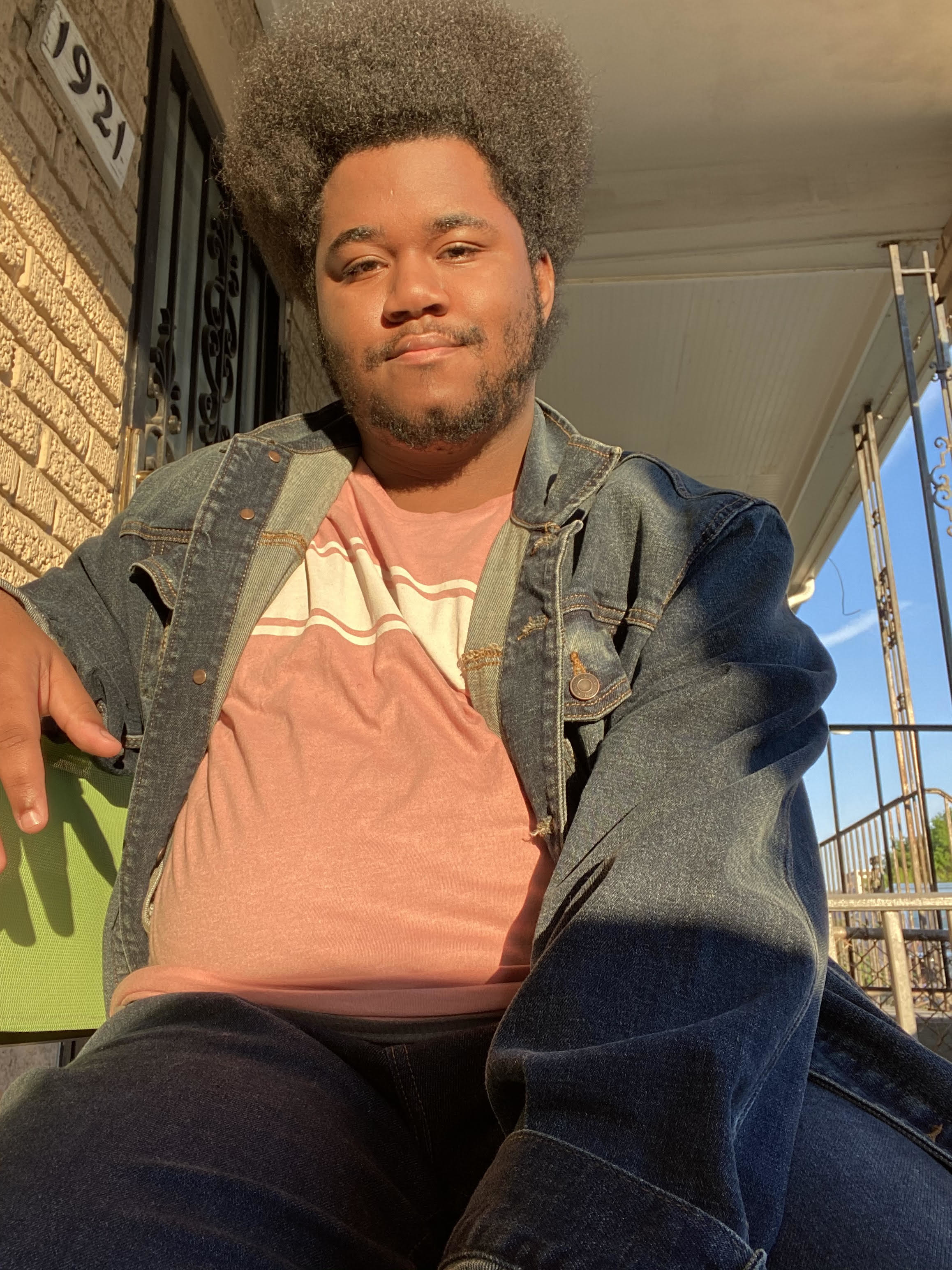 a man poses for a photo on his front porch