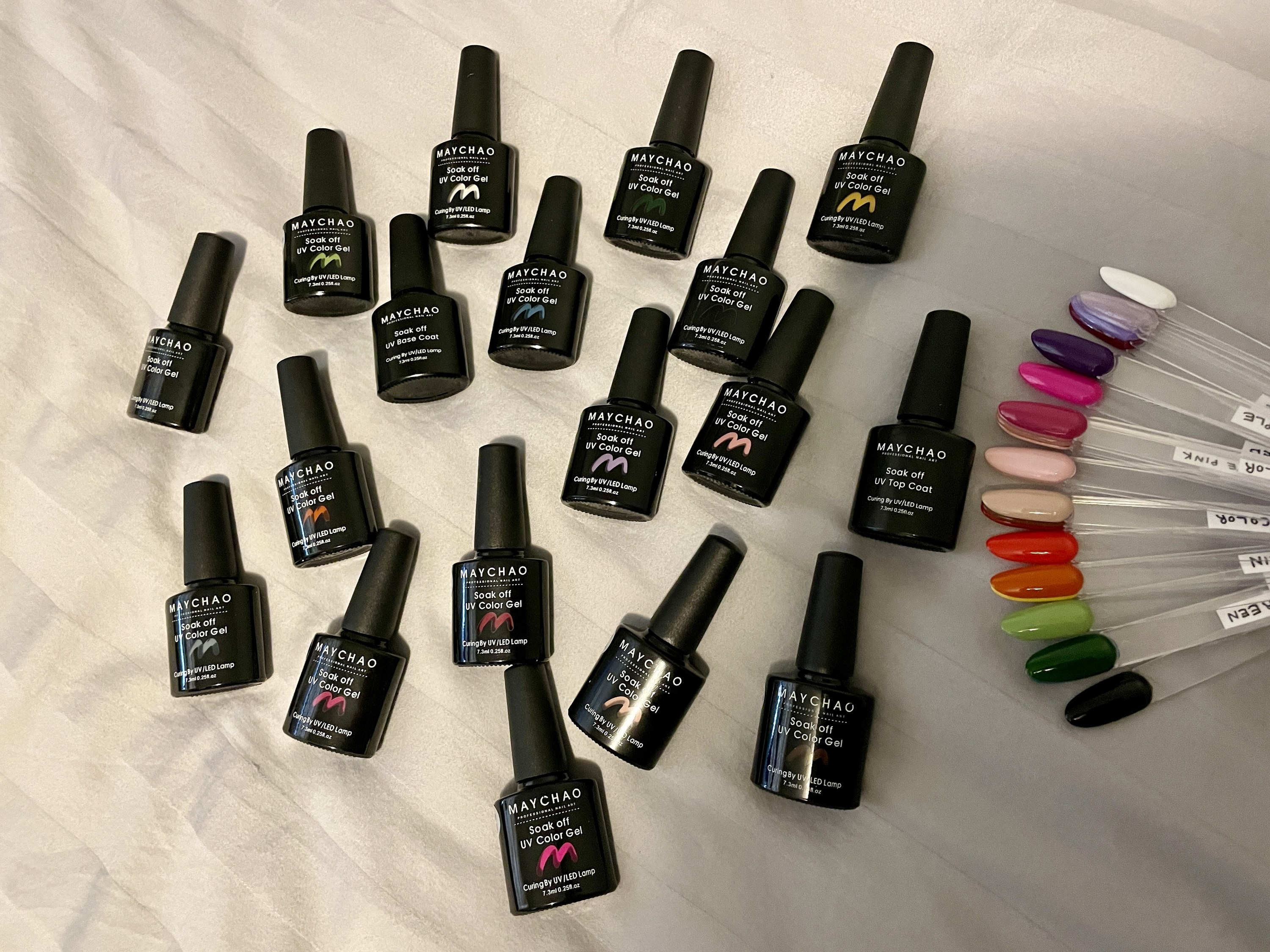 the nail polishes scattered on a bed next to a colour wheel
