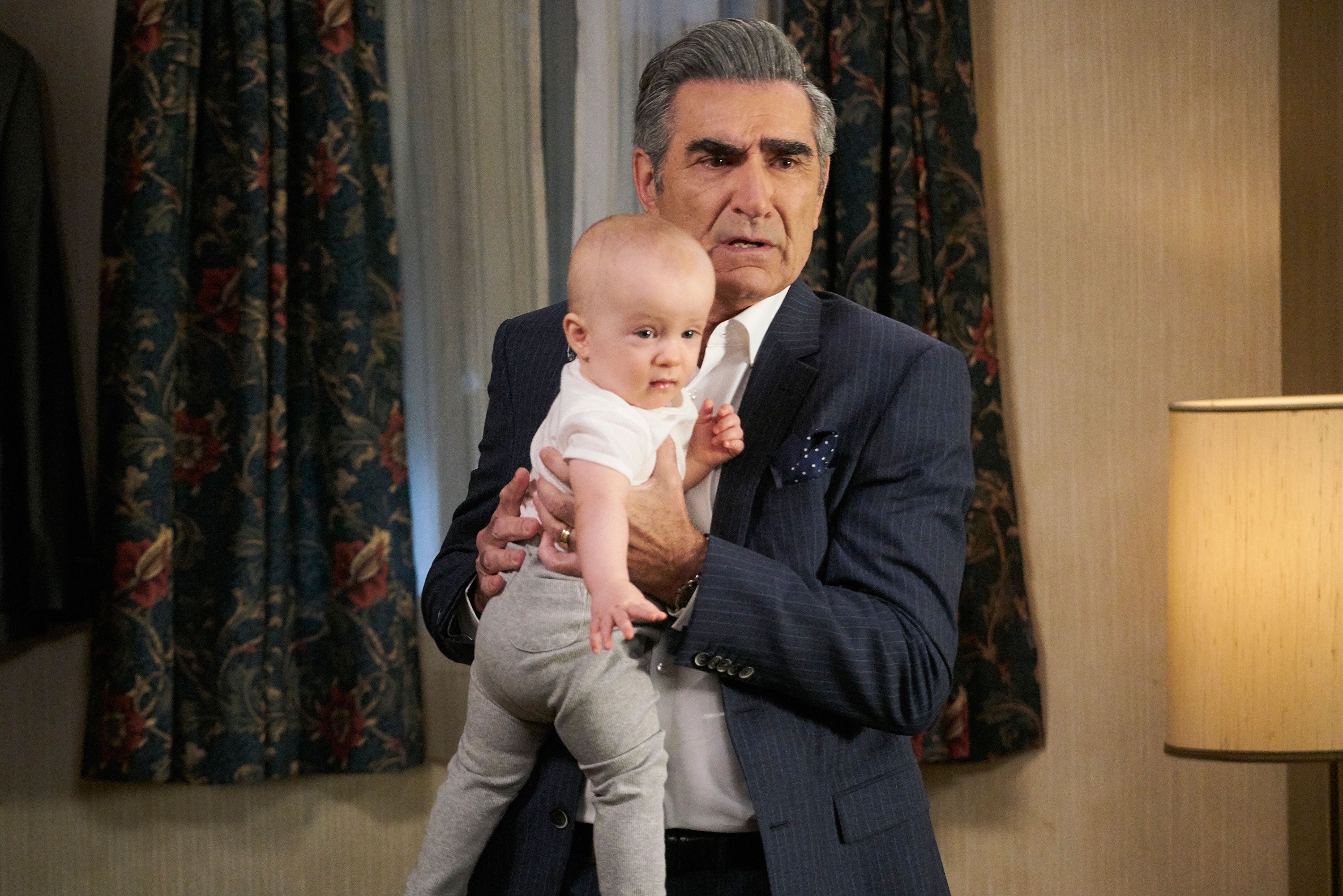 Johnny Rose looks confused while holding a baby