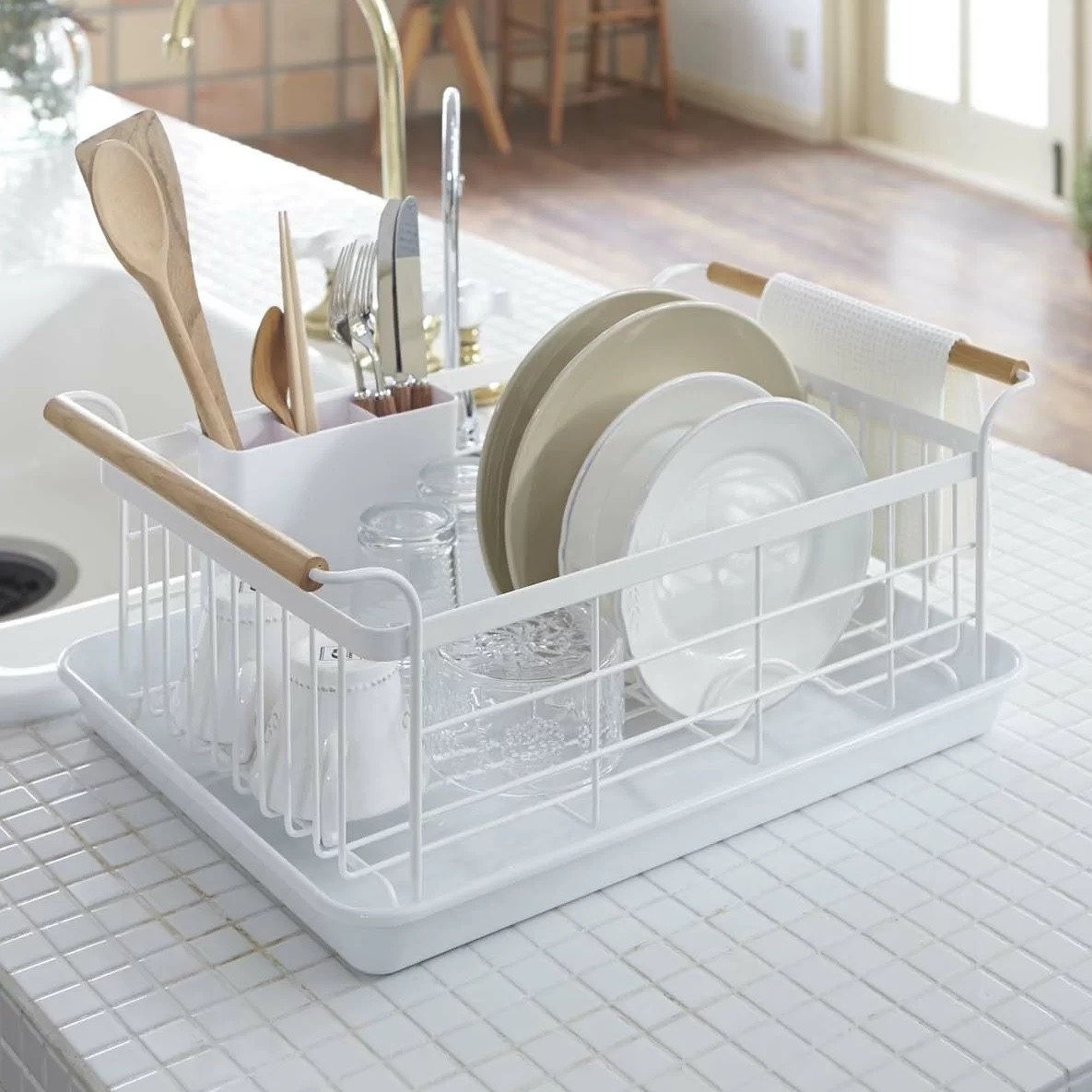 a white dish drainer rack with wooden handles