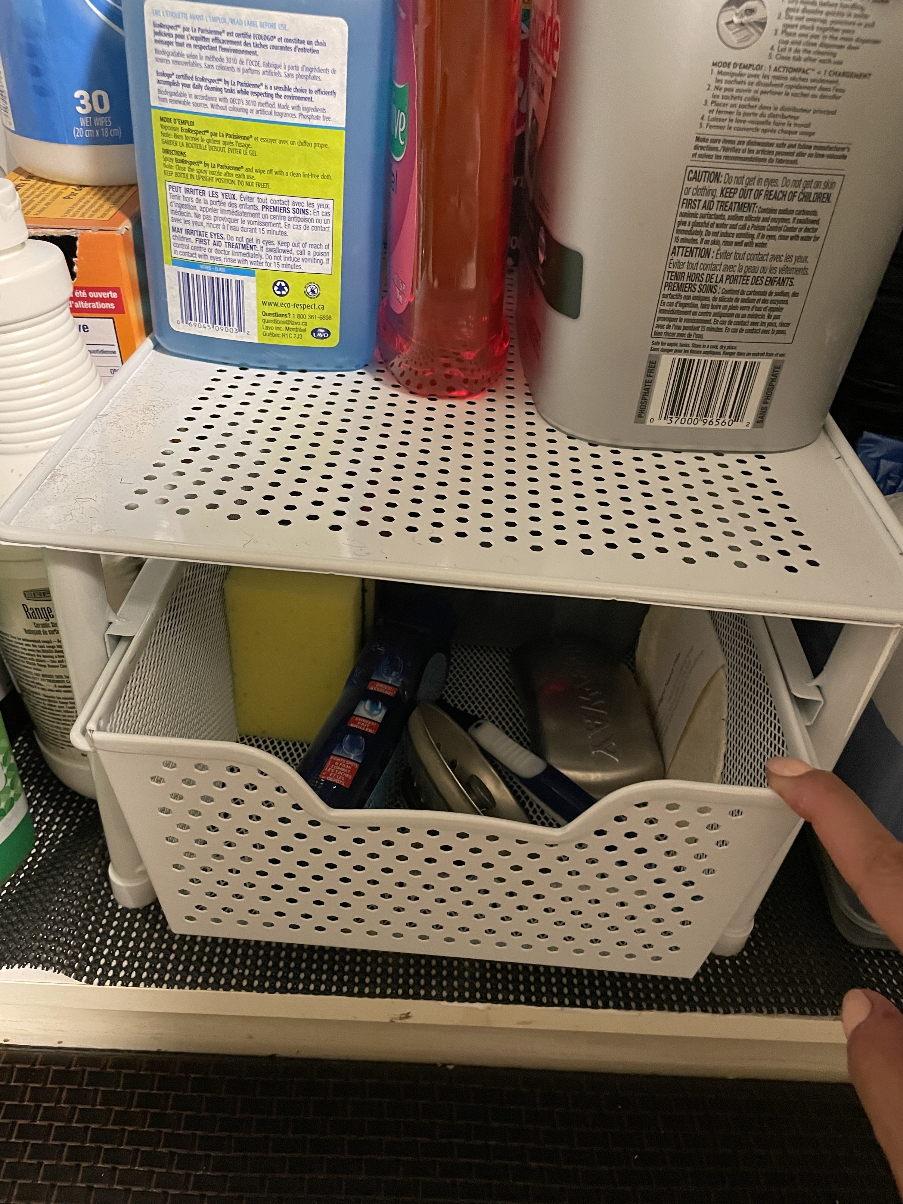 the sliding drawer filled with cleaning supplies