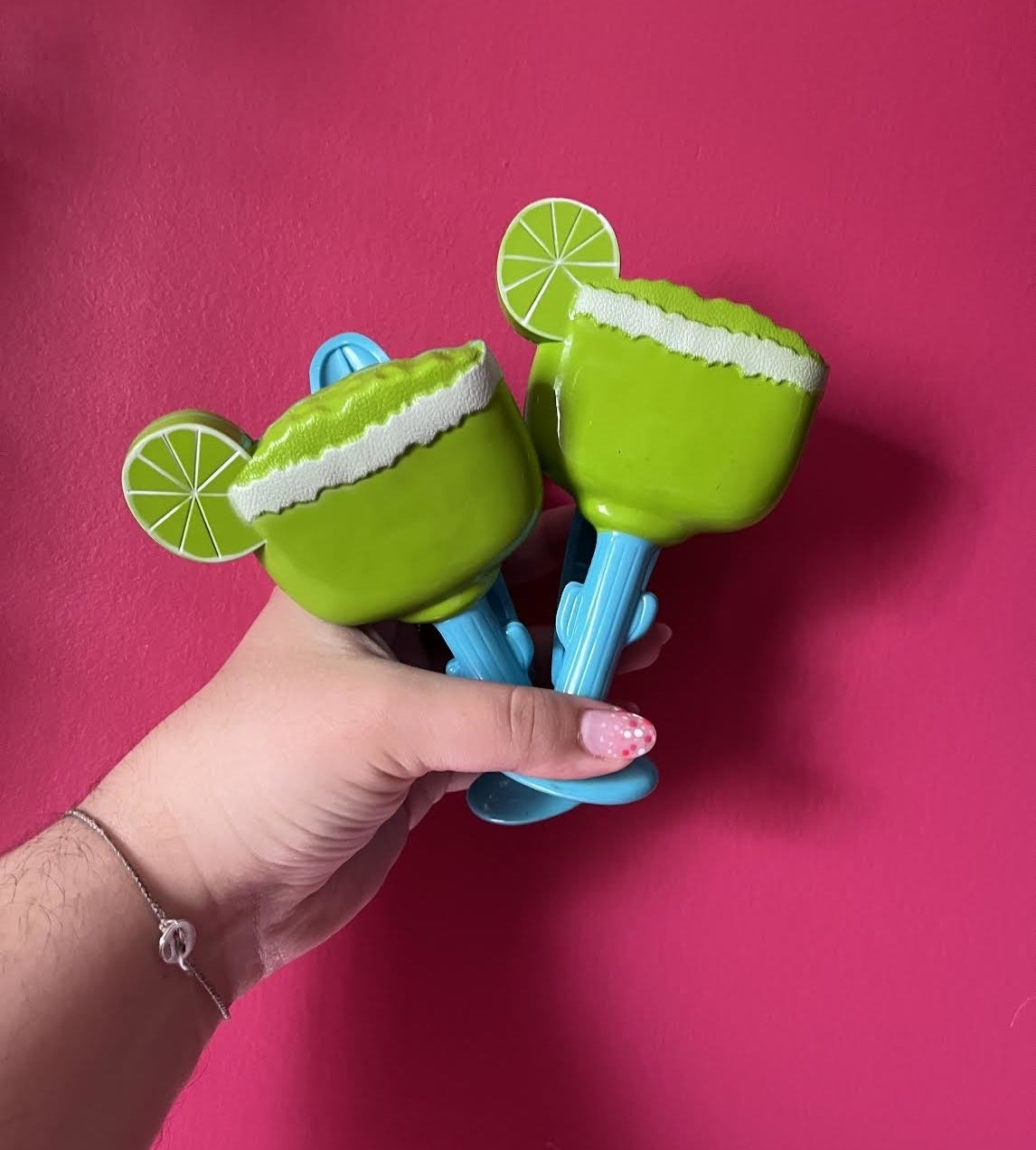Bianca holding up the margarita shaped clips against a plain wall