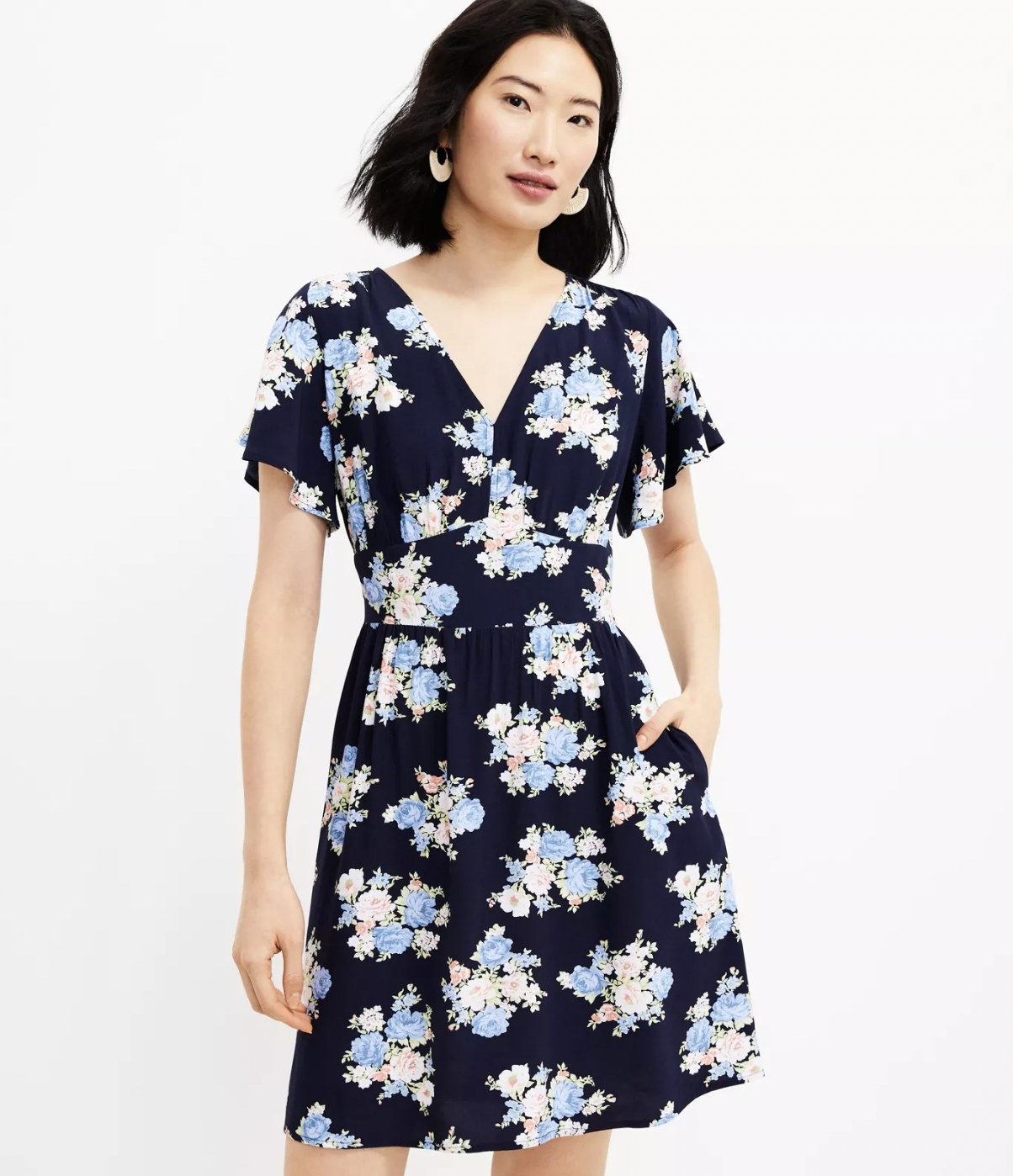 Model wearing the blue floral dress with hand in pocket