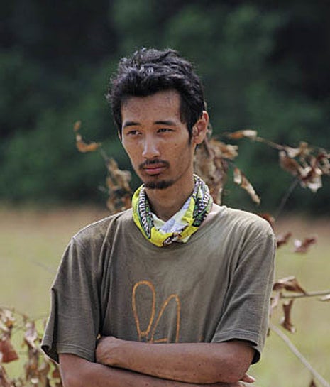 Ken Hoang stands in a field