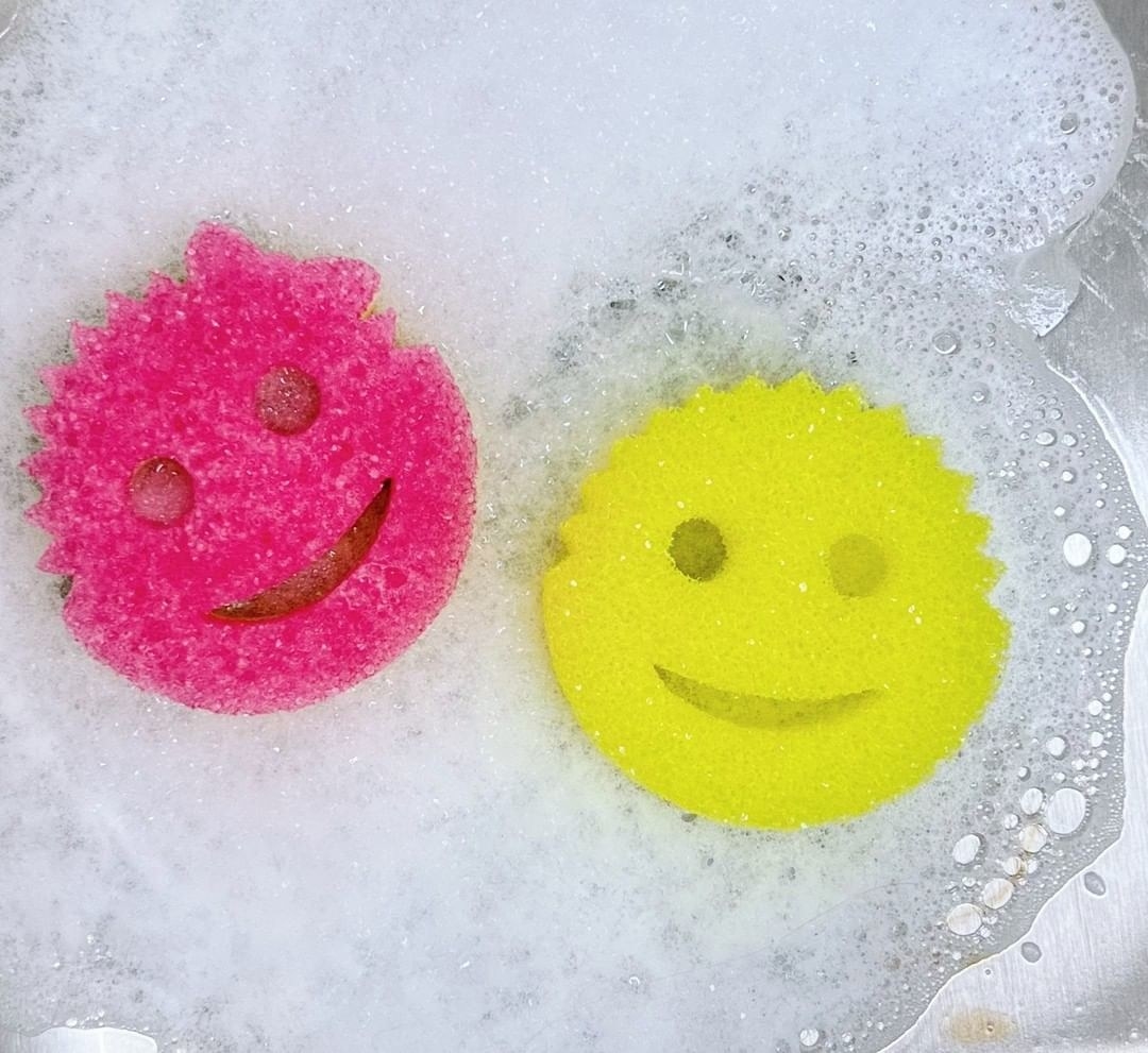 a pink and yellow scrub daddy in soap