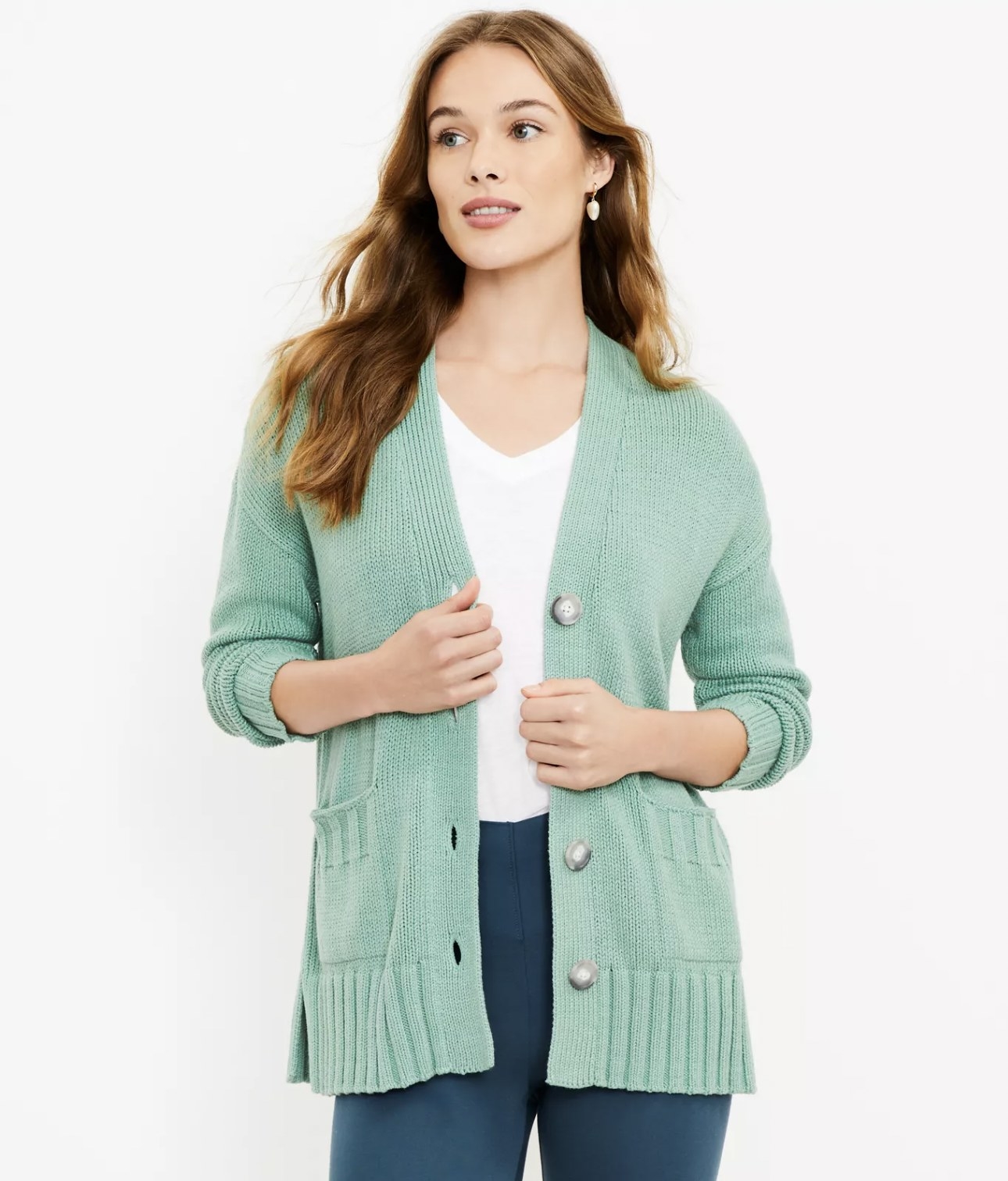 Model wearing the teal cardigan open and layered over white tee