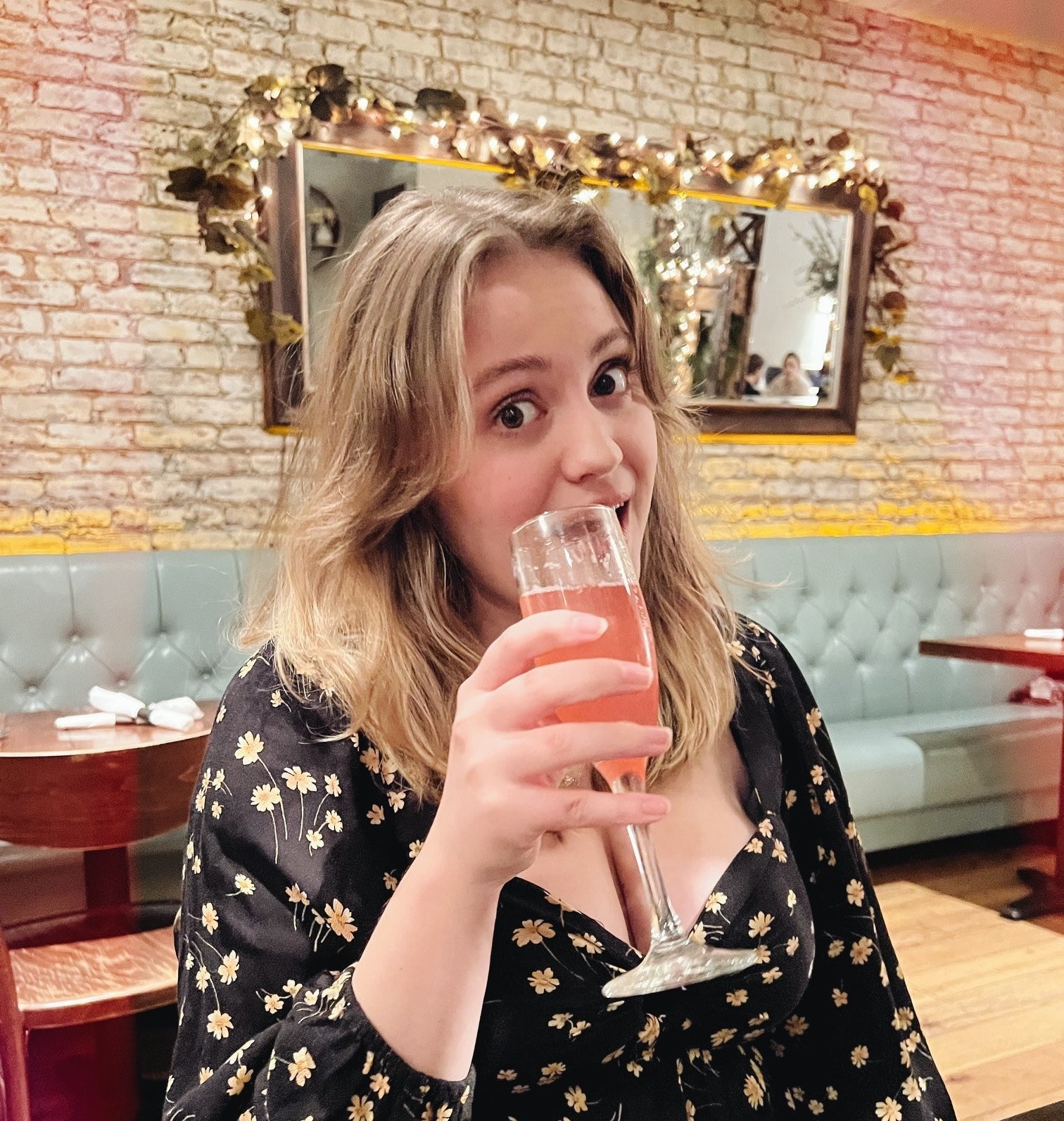 the author posing with a drink at a restaurant