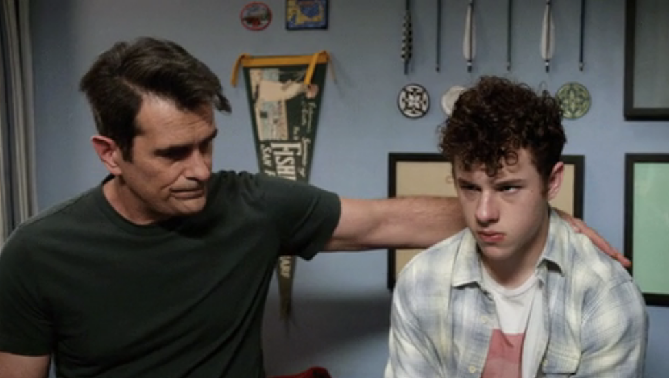 A man putting his arm around a teenager