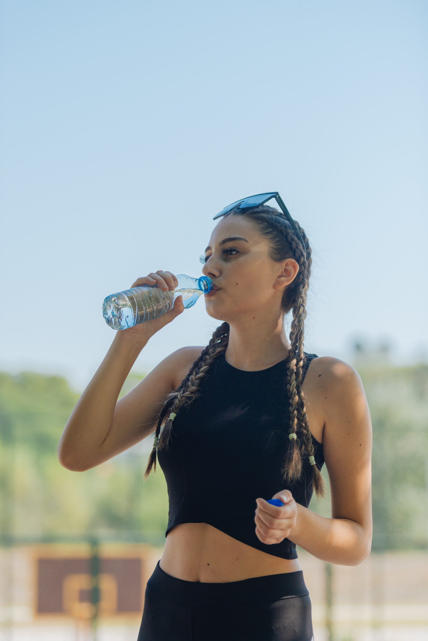 A woman drinks water outside