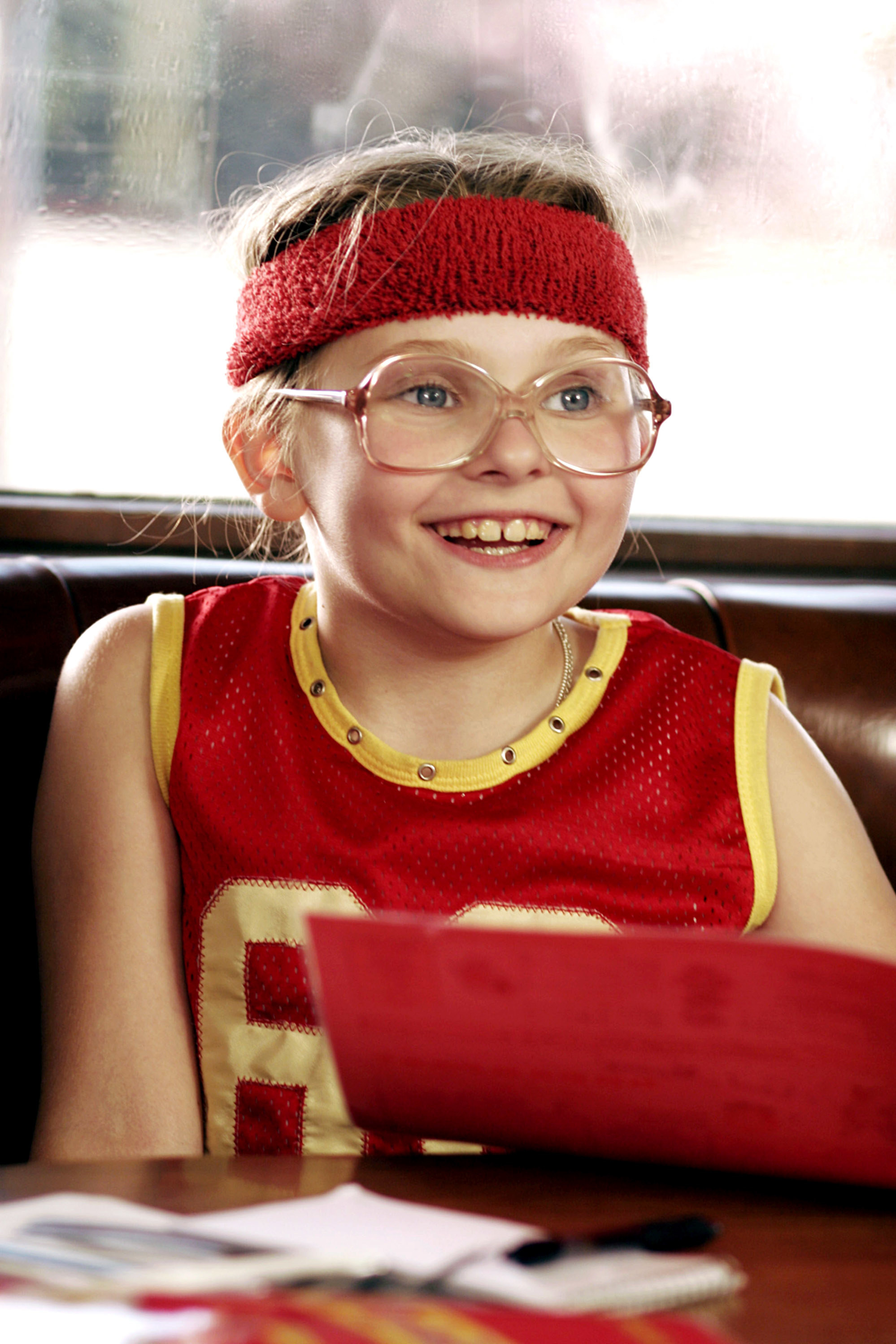 Abigail wearing glasses, a jersey, and a sweatband on a her head