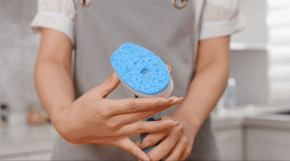 A gif of a model using a soap dispensing dish brush
