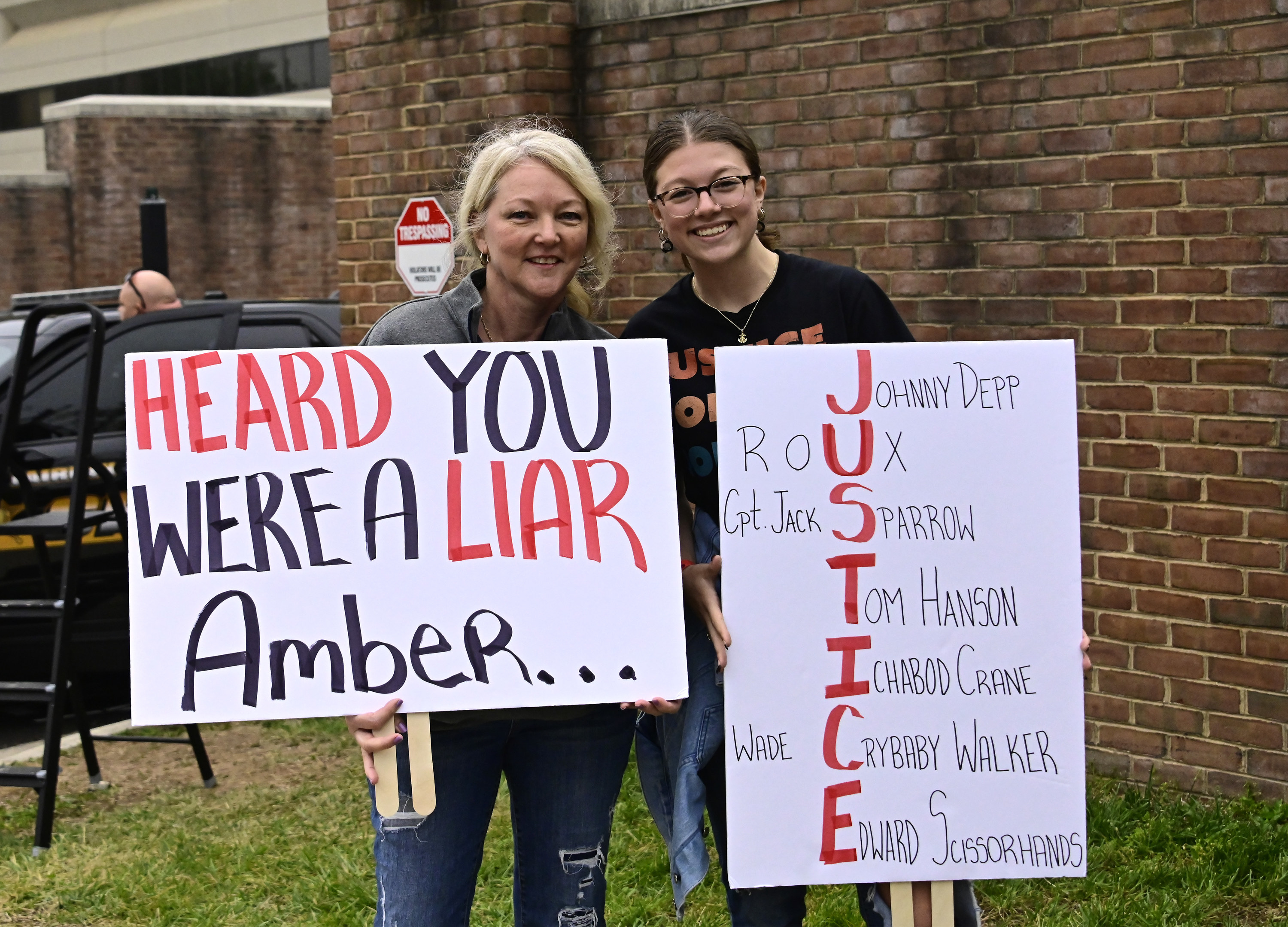 signs read &quot;heard you were a liar amber&quot; and &quot;justice&quot; for johnny depp
