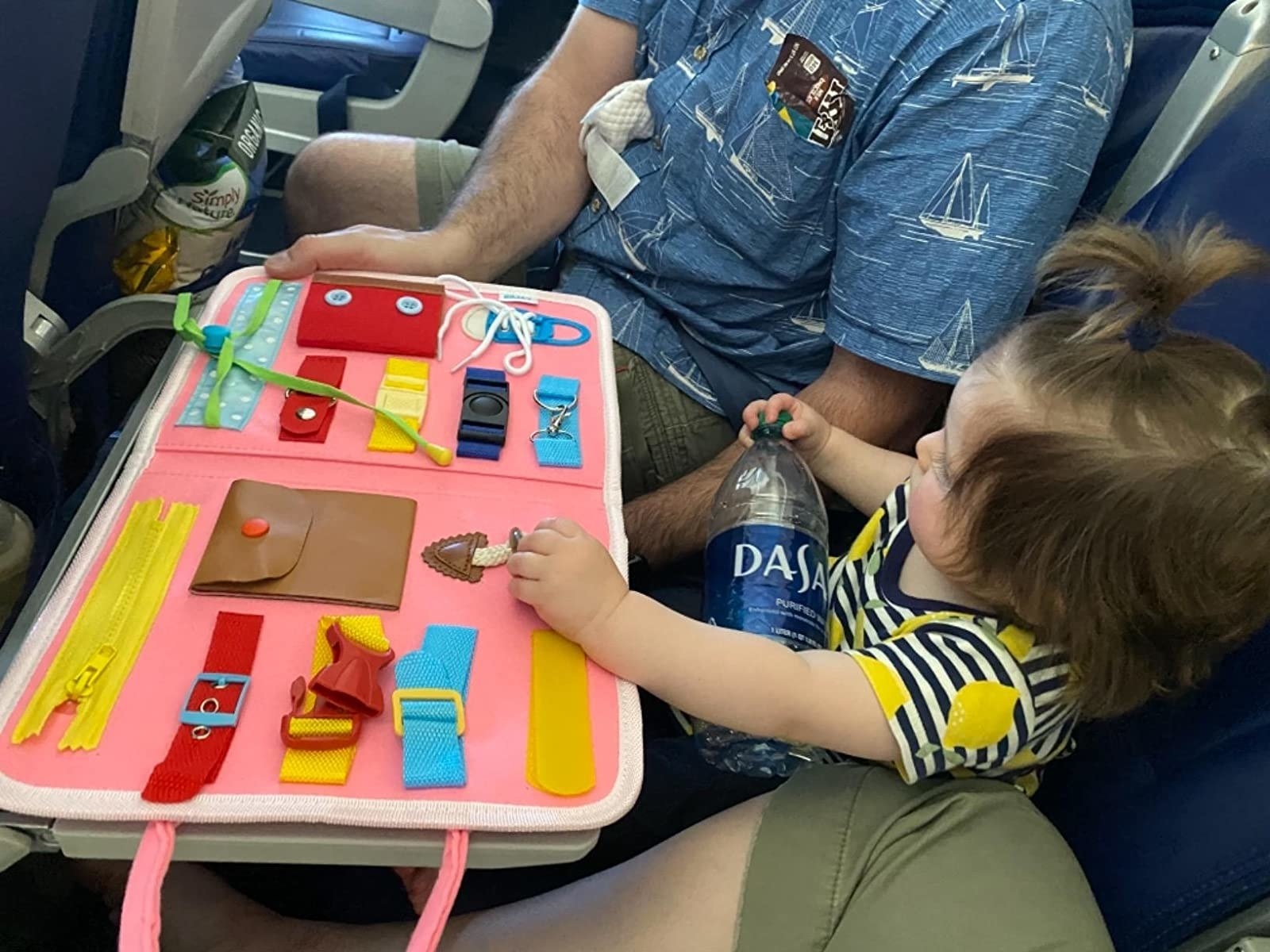 reviewer showing a toddler using the board on a flight