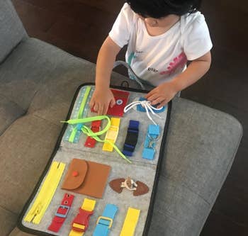 reviewer's child playing with the busy board