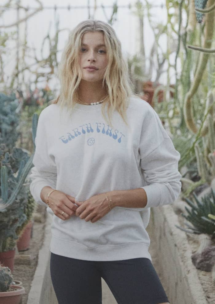 Someone standing and wearing an Earth First sweater