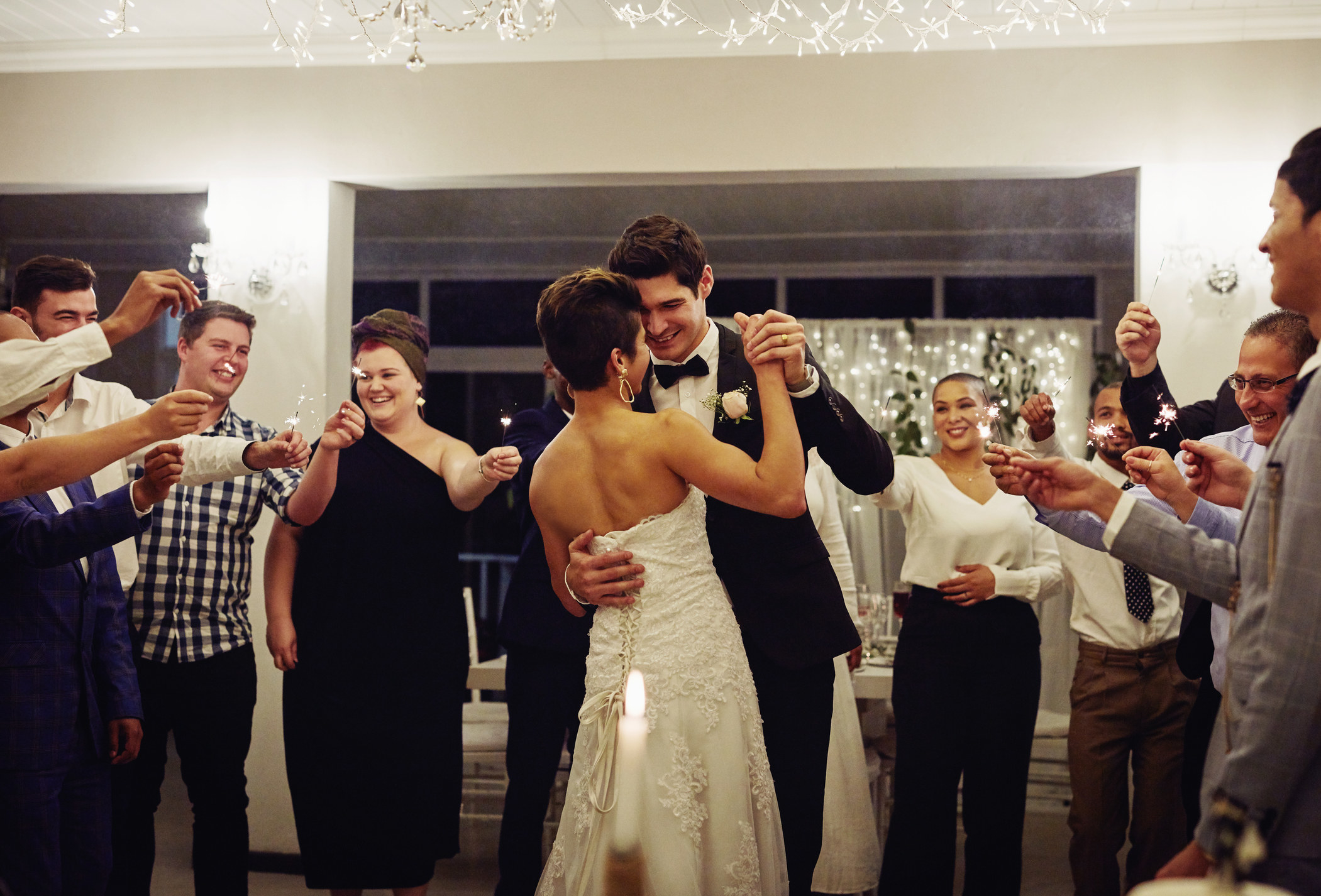 people circling the bride and groom as they dance