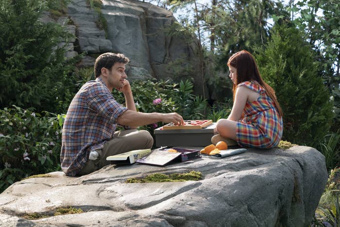 two of the characters playing checkers on a rock outside