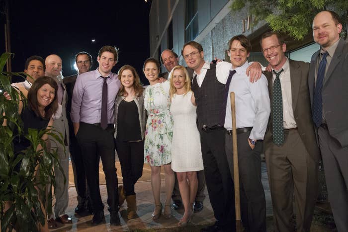 the cast posing at night after filming