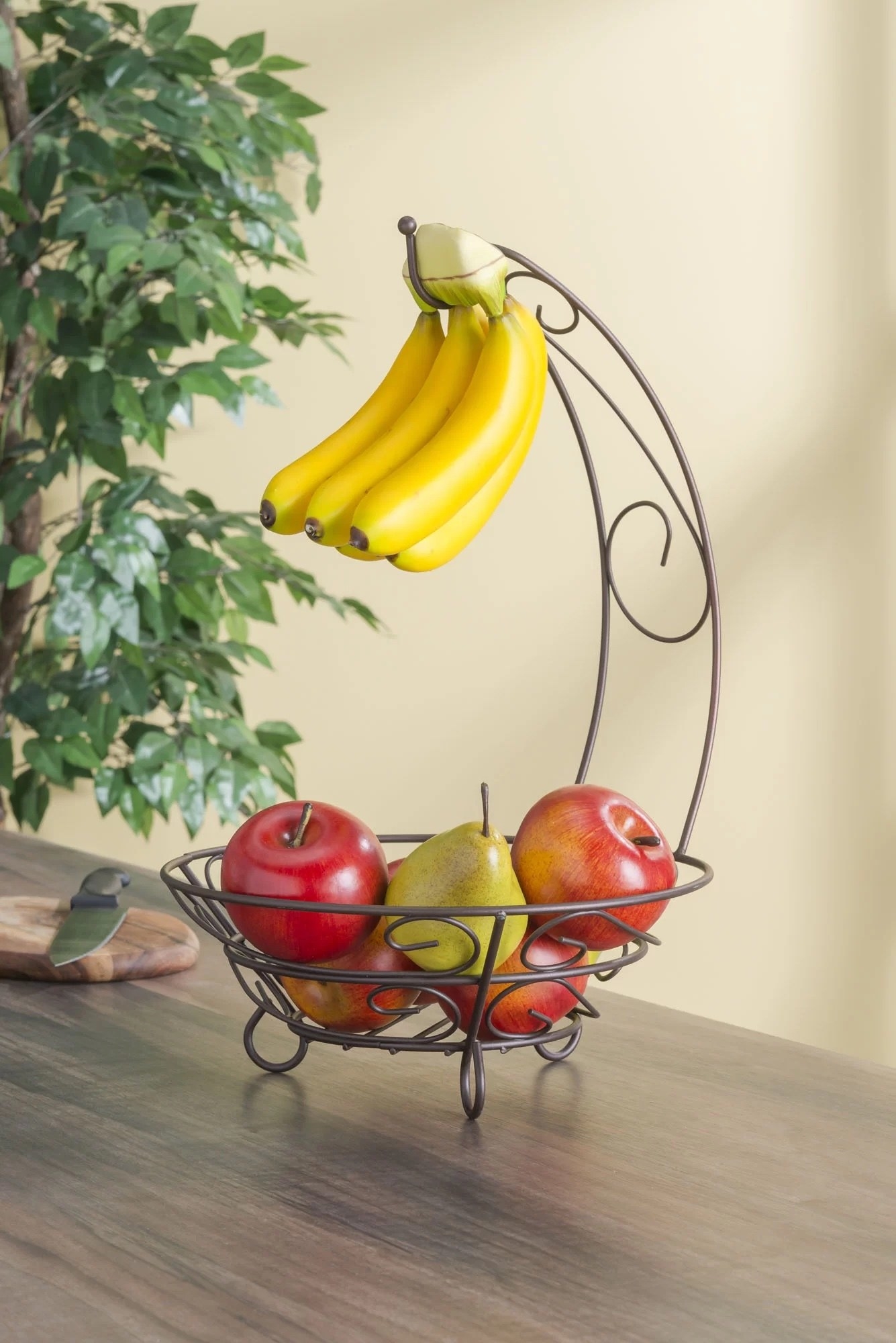 a banana holder holding bananas and apples and pears