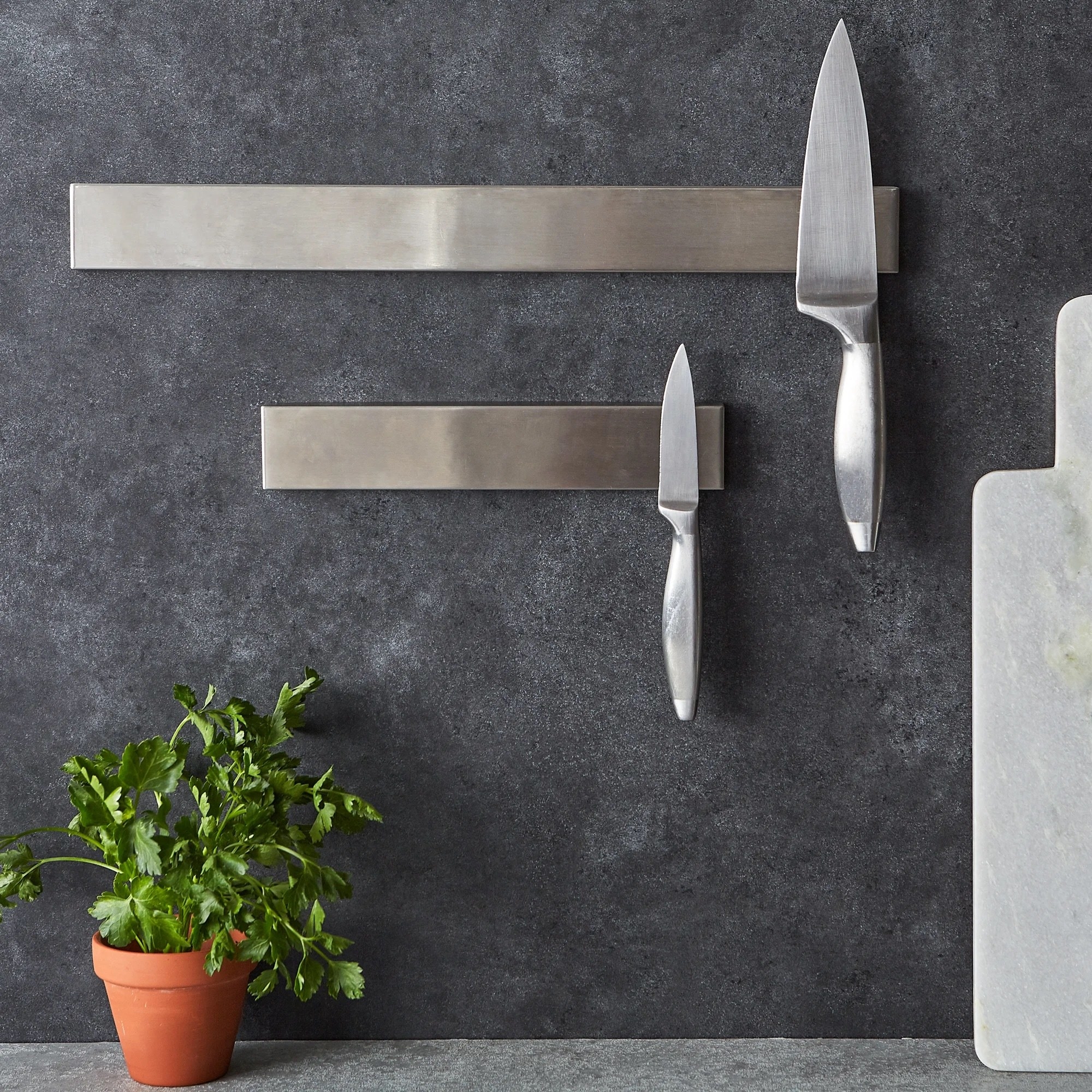 two magnetic knife holders with two kitchen knives attached