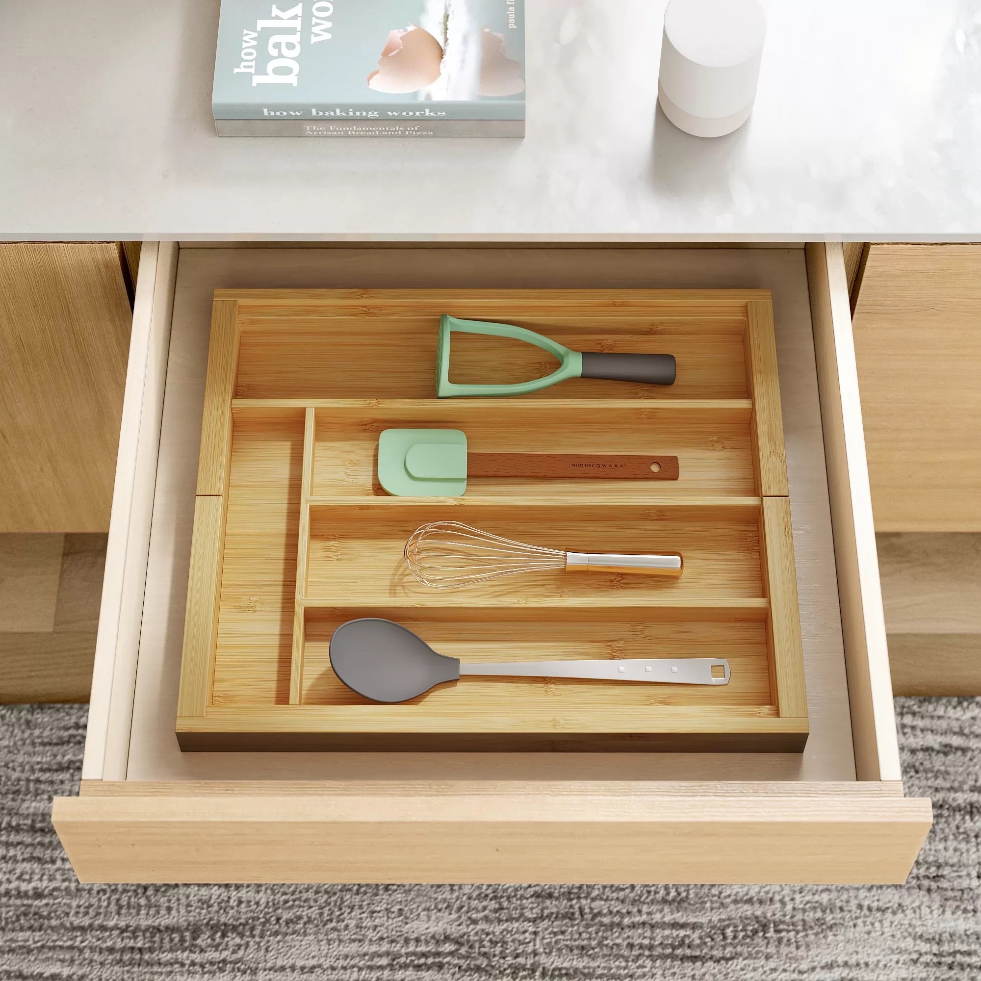 an wooden adjustable flatware and utensil organizer in a kitchen drawer holding utensils