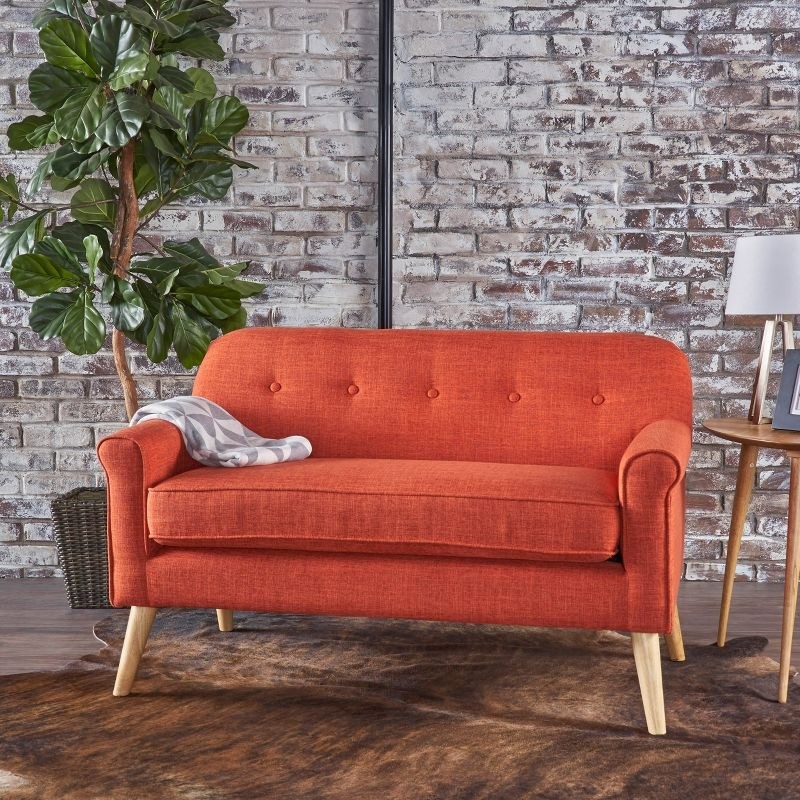 The loveseat in muted orange in a home