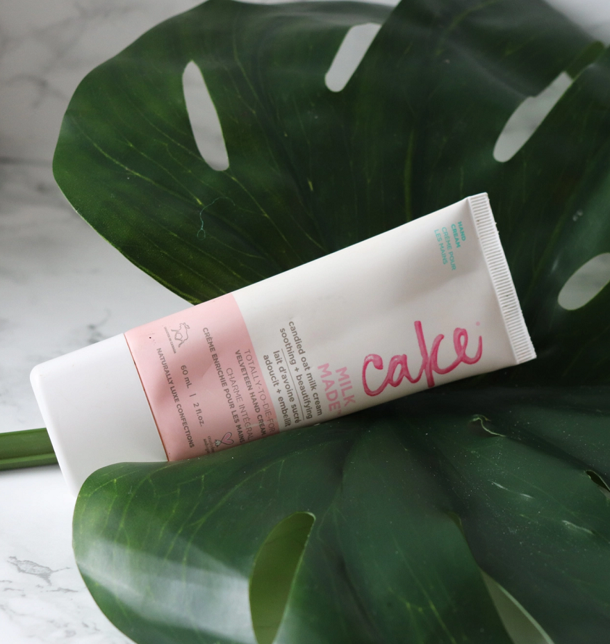 A tube of hand cream lying on a large fake palm leaf