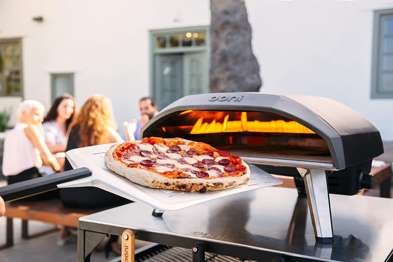 a pizza oven with a pizza being slid into it