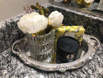 reviewer image of the tray in silver with a candle and vase with flowers on it
