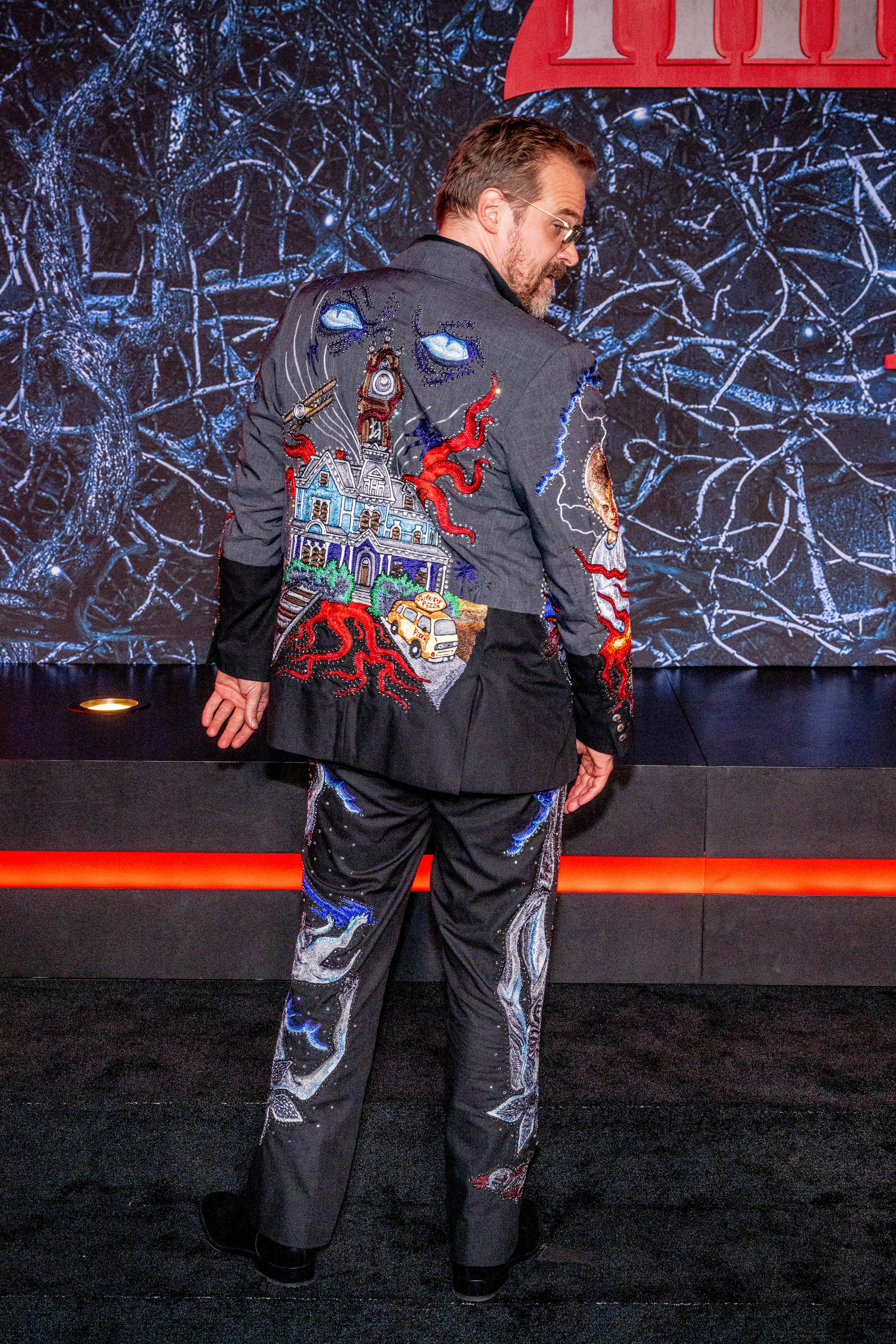 David turned around to show the back of the suit, which is covered with an artistic rendering of the main house from Stranger Things