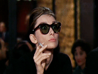 Audrey Hepburn lowering her sunglasses and blinking