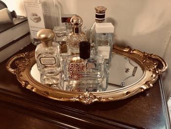 reviewer image of the mirrored tray in gold with perfume bottles on it