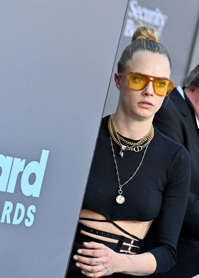 Cara Delevingne peeking out from a Billboard Music awards sign
