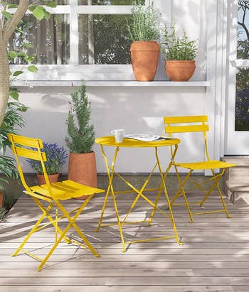 the yellow bistro set on an outdoor patio