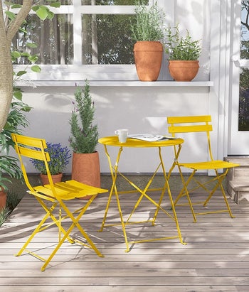 the yellow bistro set on an outdoor patio