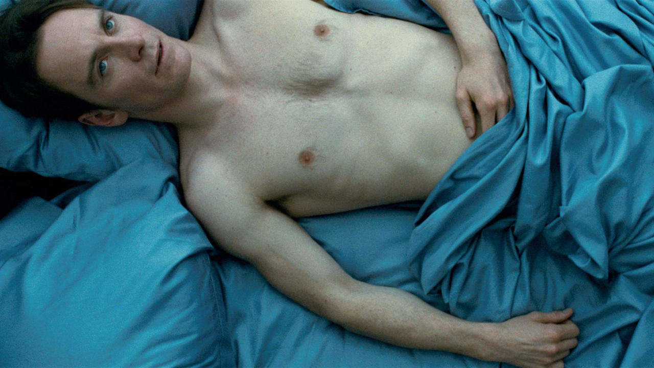 Michael Fassbender in a bed, shirtless